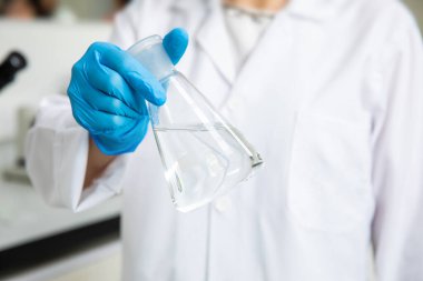 Tıbbi teknoloji araştırma laboratuvarında deney tüpüyle çalışan bir bilim adamı. Koronavirüs, covid-19 aşısı üzerinde çalışan kimyager ya da biyogenetik doktor.