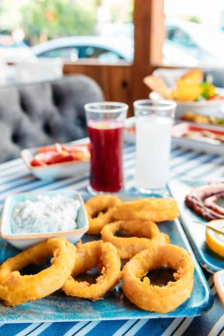 Izgara balık, salata ve sebze. Deniz ürünleri, ızgara et, meze, rakı, uzo, aperatifler ve salatalar Yunan ya da Türk Balık Restoranı 'nda akşam yemeği ya da sahilde öğle yemeği için masaya..