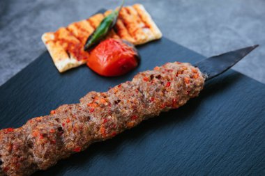 Traditional Turkish grilled shish kebab or kebap. Delicious Adana kebab on black background.