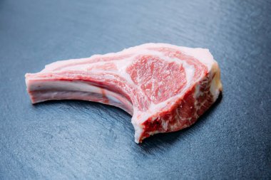 Siyah arka planda çiğ ve taze kuzu pirzola bifteği..