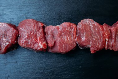 Taze ve çiğ şiş kebap ya da ızgara Şiş et eti. Siyah arka planda çiğ ve taze biftek..
