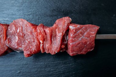 Taze ve çiğ şiş kebap ya da ızgara Şiş et eti. Siyah arka planda çiğ ve taze biftek..