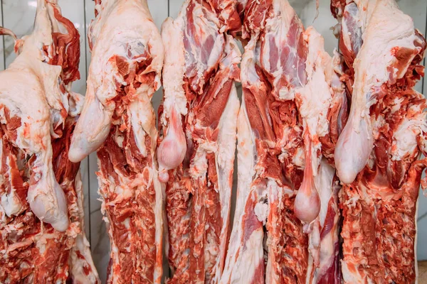 Hanging sheep meat in the butcher shop. Cattles cut and hanged on hook in a slaughterhouse. Halal cutting.