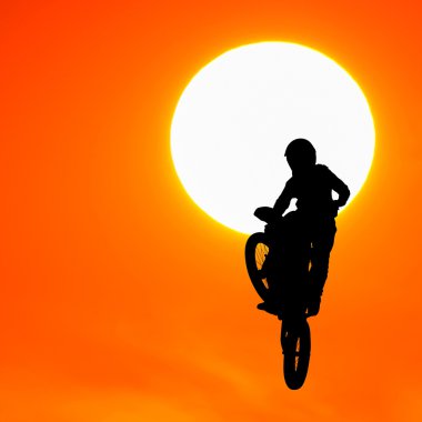 gün batımında gökyüzünde motocross binici atlama silüeti