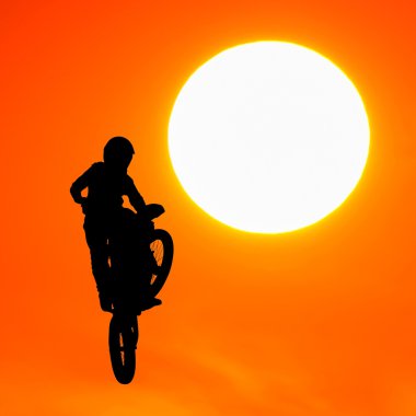 gün batımında gökyüzünde motocross binici atlama silüeti
