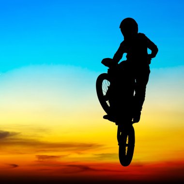 gün batımında gökyüzünde motocross binici atlama silüeti