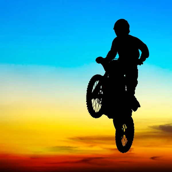 Silhouette of motocross rider jump in the sky at sunset — Stock Photo, Image