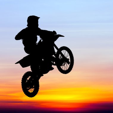 gün batımında gökyüzünde motocross binici atlama silüeti