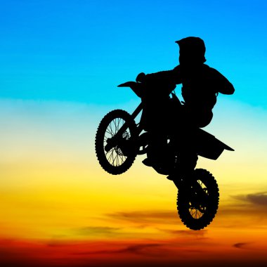 gün batımında gökyüzünde motocross binici atlama silüeti