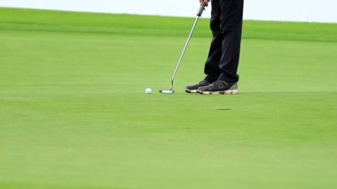Golf topunu yeşile koyan bir golfçü