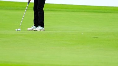 Golf topunu yeşile koyan bir golfçü