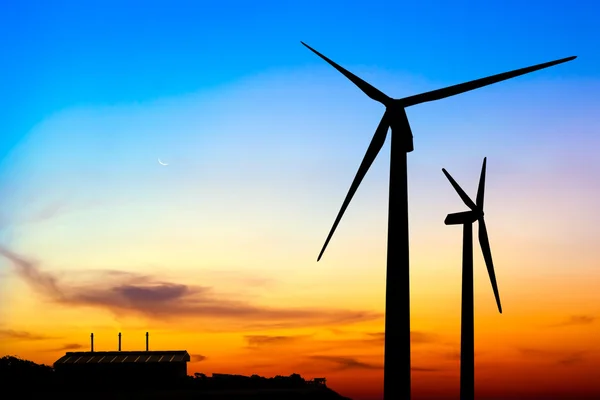 Silhouette wind turbine generator with factory emissions of carb — Stock Photo, Image