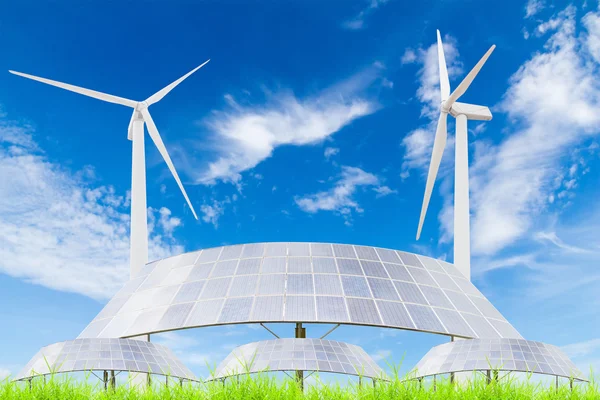 Painéis solares e turbina eólica no campo de grama verde contra azul — Fotografia de Stock