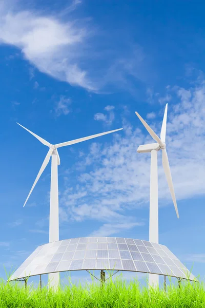 Painéis solares e turbina eólica no campo de grama verde contra azul — Fotografia de Stock