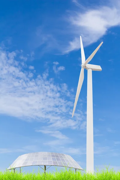 Zonnepanelen en windturbine op groen grasveld tegen blauw — Stockfoto