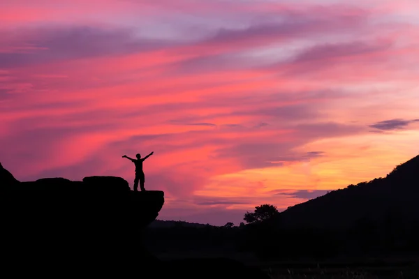 Silhueta de um homem na rocha ao pôr-do-sol — Fotografia de Stock