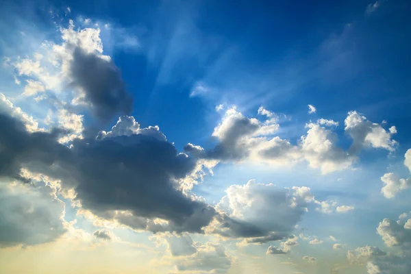 Schöner blauer Himmel mit Wolken und Sonnenstrahlen — Stockfoto