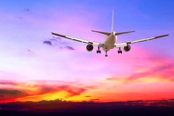 Commercial airplane flying at sunset — Stock Photo, Image