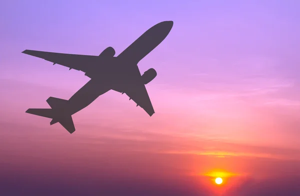 Siluett kommersiella flygplan flyger på sunset — Stockfoto