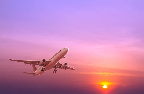 Commercial airplane flying at sunset — Stock Photo, Image
