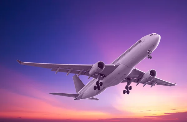 Commercial airplane flying at sunset — Stock Photo, Image