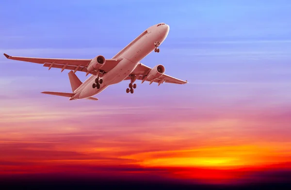 Commercial airplane flying at sunset — Stock Photo, Image