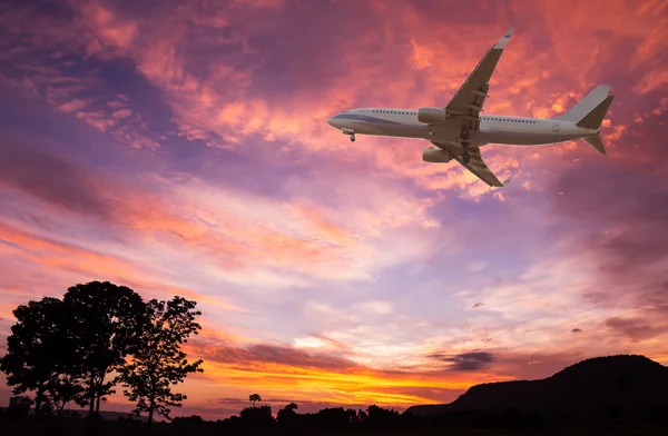 Commercial airplane flying at sunset — Stock Photo, Image