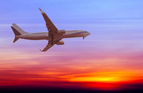 Avião comercial voando ao pôr do sol — Fotografia de Stock