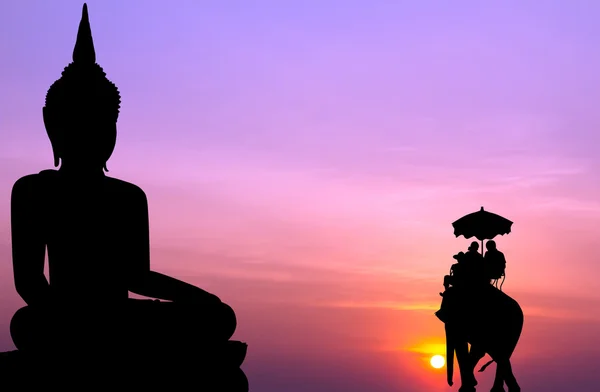 Siluetti norsu turisti edessä iso buddha auringonlaskun aikaan — kuvapankkivalokuva