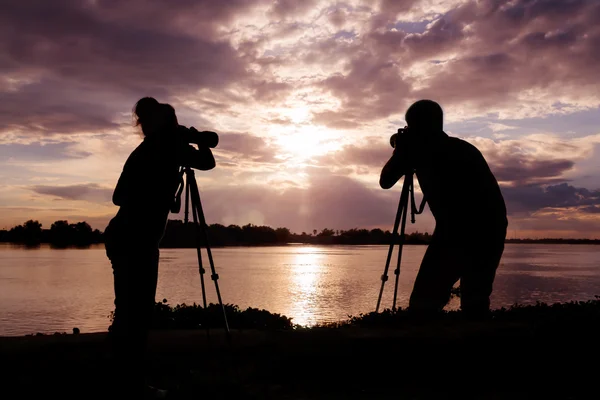 Silueta del fotógrafo tomando fotos al atardecer — Foto de Stock