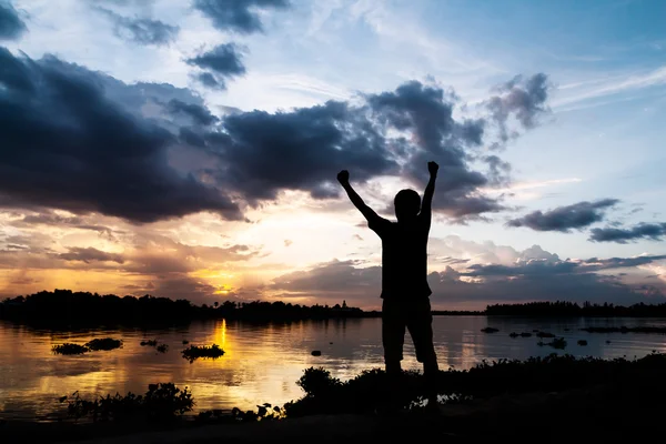 Silhouette d'un homme tenir ses mains comme indiquant le succès à côté — Photo