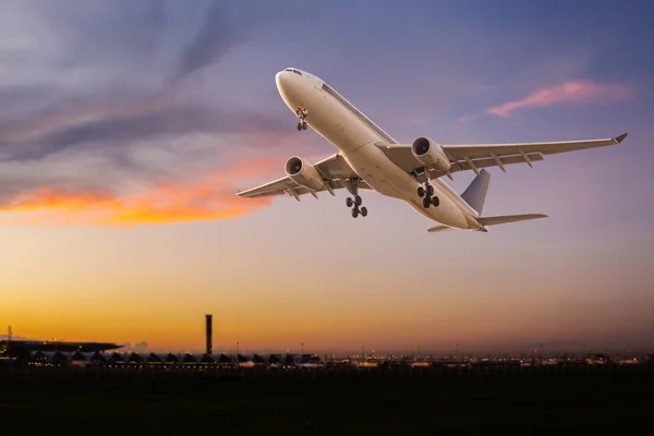 Avião comercial decolando ao pôr do sol — Fotografia de Stock