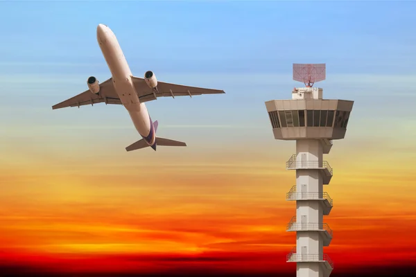 Avião comercial decolar sobre torre de controle do aeroporto em sunse — Fotografia de Stock