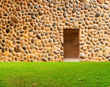 taş duvar ile kapı ve çim zemin önünde kapalı