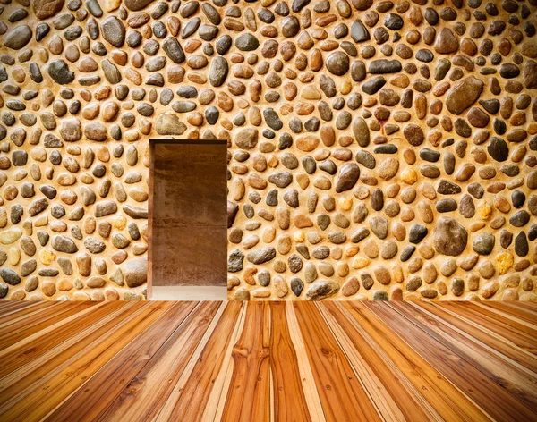 Pared de piedra con puerta y suelo de madera en frente —  Fotos de Stock