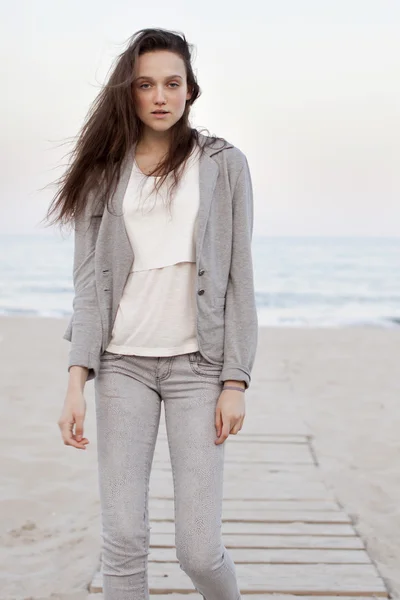 Retrato de moda de una chica posando en la playa al atardecer con una ropa cómoda y elegante. Mujer joven al aire libre —  Fotos de Stock