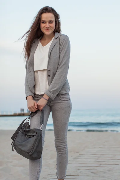 スタイリッシュな快適な服で夕暮れ時のビーチでポーズの女の子のおしゃれな肖像画。若い女性アウトドア — ストック写真