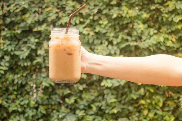 Hand hålla glas iskallt kaffe med vintage filtereffekten — Stockfoto