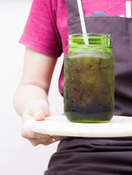 Barista serving iced black coffee