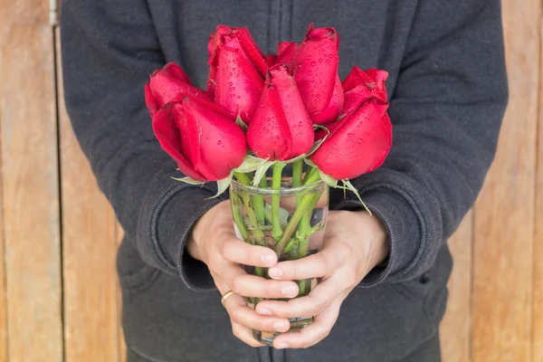 Hand hold glass of red rose — Stock Photo, Image