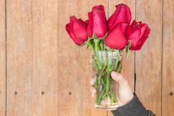 Hand hold glass of red rose — Stock Photo, Image