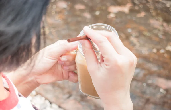 Mão sobre o vidro de café de leite gelado com efeito de filtro vintage — Fotografia de Stock