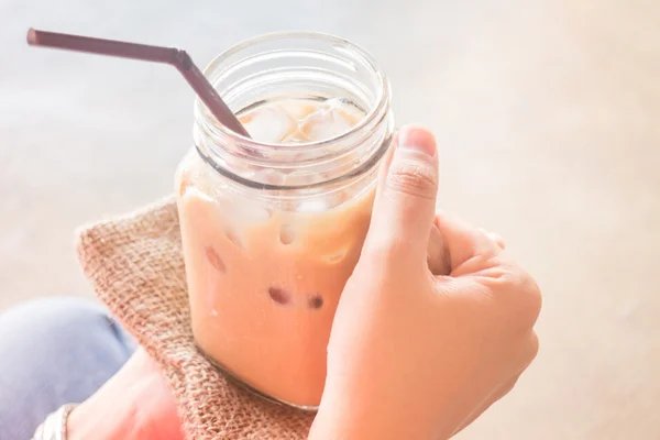 Main sur verre de café au lait glacé avec effet filtre vintage — Photo