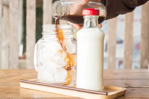 Pouring espresso to iced glass of coffee — Stock Photo, Image