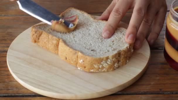 Topping whole wheat bread with peanut butter — Stock Video