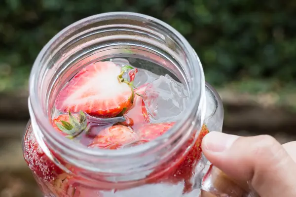 Mão segurar vidro de refrigerante de morango gelado — Fotografia de Stock
