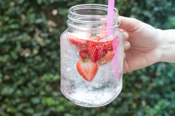 Hand houd glas van iced aardbei soda drank — Stockfoto