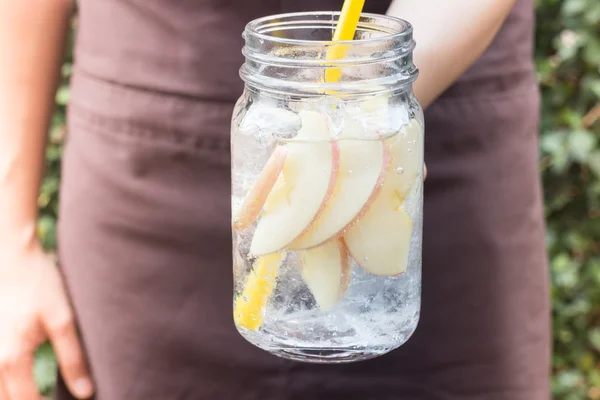 Ruku na podává sklenici ledový jablečný nápoj soda — Stock fotografie