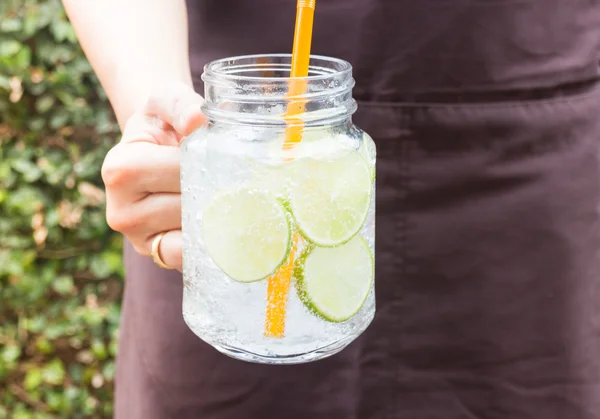 Mano en vaso de bebida de refresco de cal helada — Foto de Stock