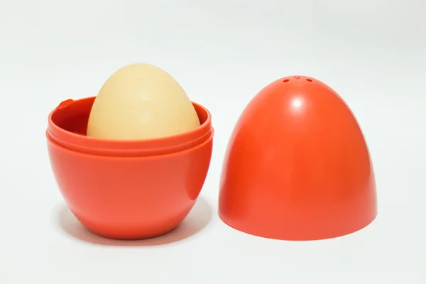Huevo de plástico rojo sobre mesa blanca —  Fotos de Stock